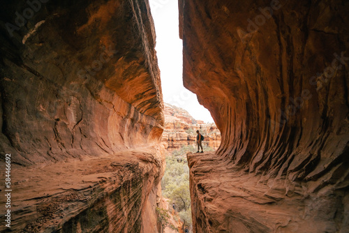 Tableau sur toile Young 30s woman steps out onto ledge in Subway Cave Boynton Canyon Az