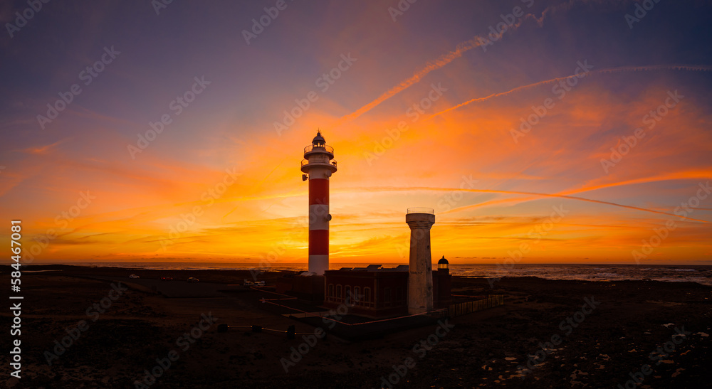 Stunningly beautiful sunset behind the historic Faro del Toston traditional lighthouse near El Cotillo and Corralejo in Fuerteventura Canary Islands Spain