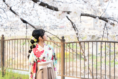 小学校の卒業式にはかま姿で桜を見ている女の子