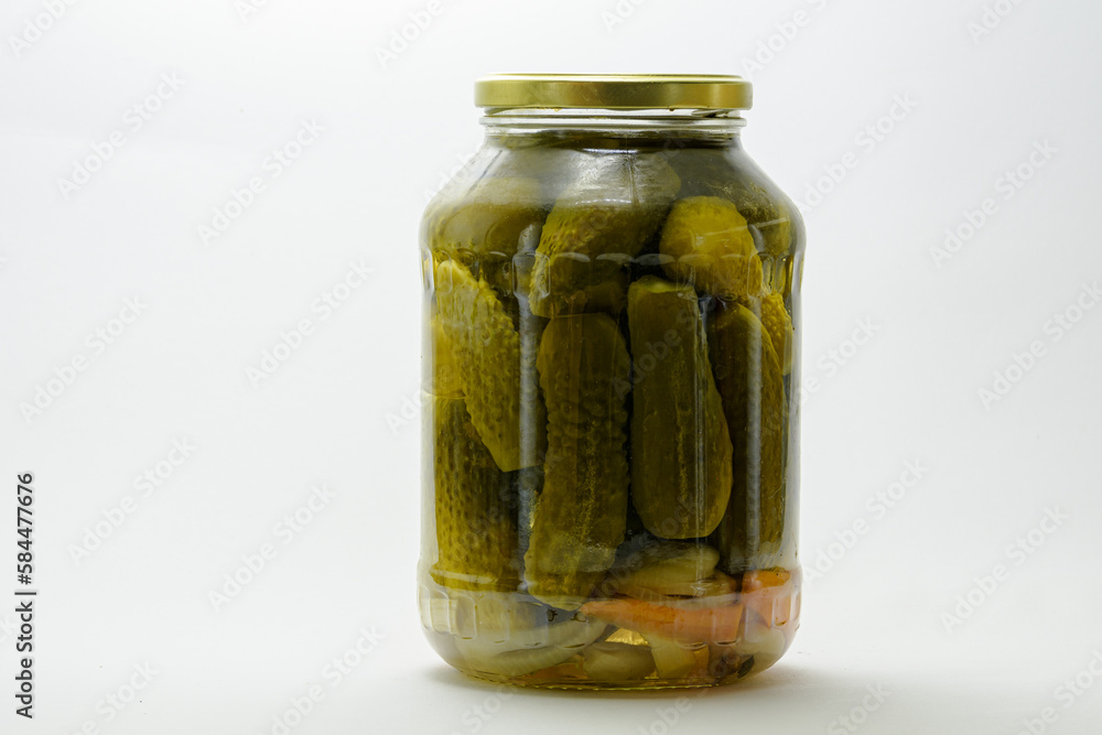 A jar of canned cucumbers. Pickled cucumbers in a glass jar on a white background. A jar of canned cucumbers. Pickled cucumbers in a glass jar on a white background.
