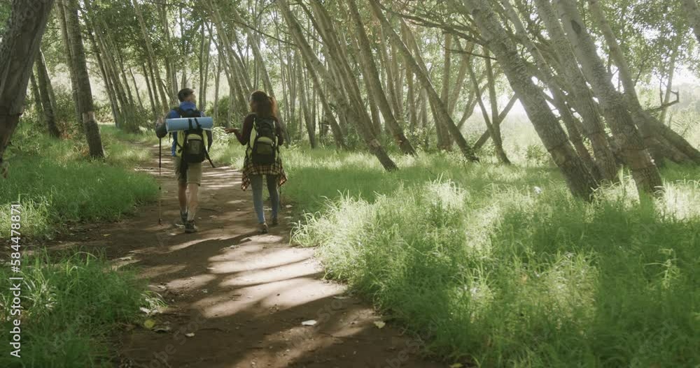 Happy african american couple hiking with trekking poles in forest, slow motion Happy african american couple hiking with trekking poles in forest, slow motion