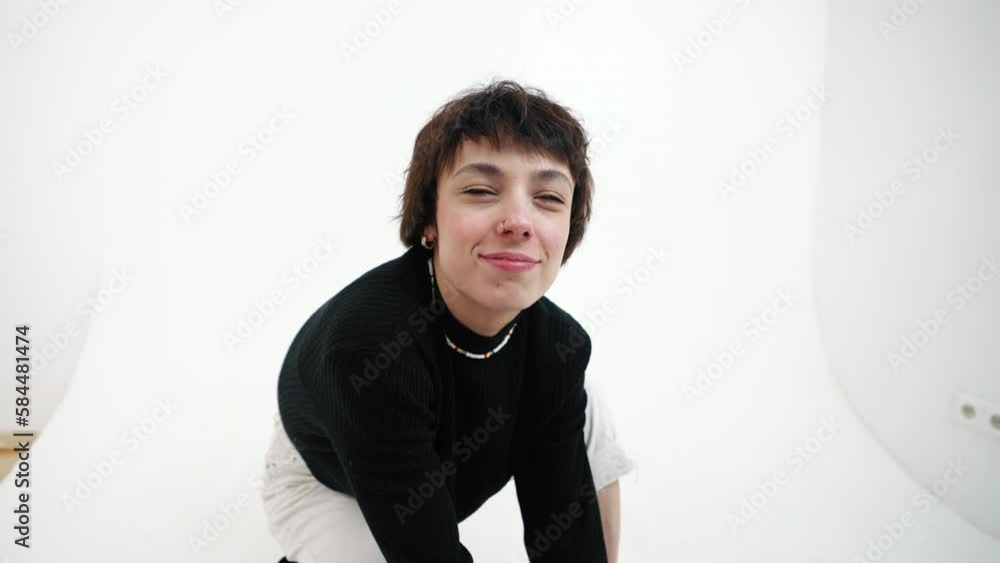 Closeup shot of squatting female fashion model doing duck face and looking at camera. Indoor studio shot over white background. High quality 4k footage Closeup shot of squatting female fashion model doing duck face and looking at camera. Indoor studio shot over white background. High quality 4k footage