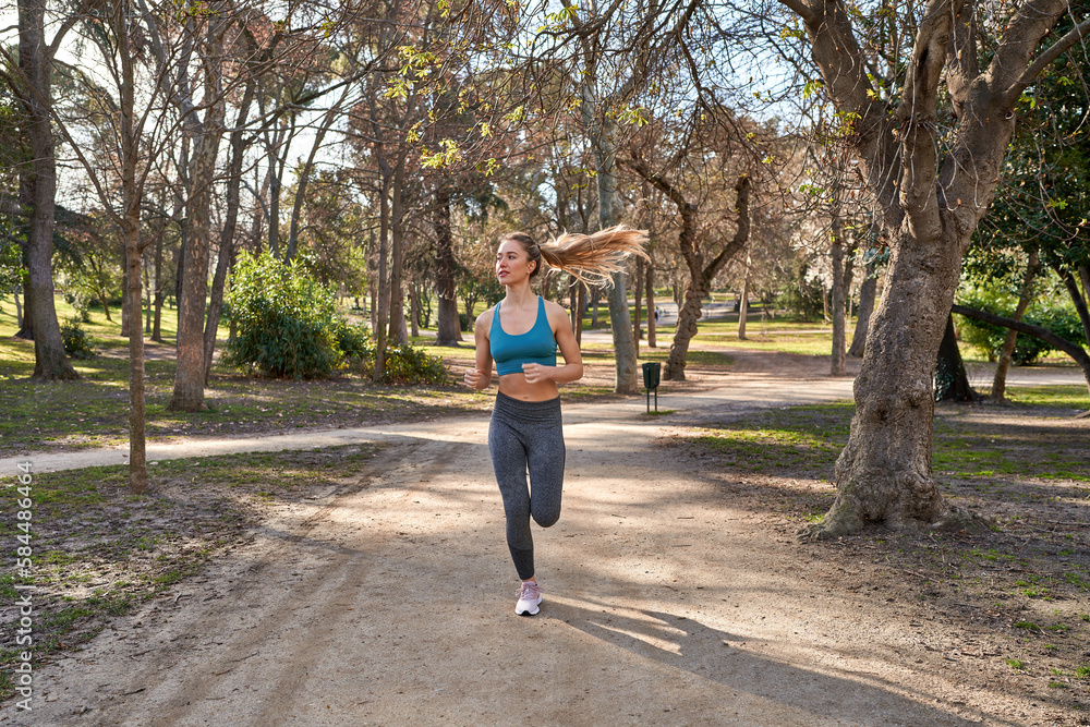 Young caucasian woman embraces the outdoors with her running routine. Young caucasian woman embraces the outdoors with her running routine.