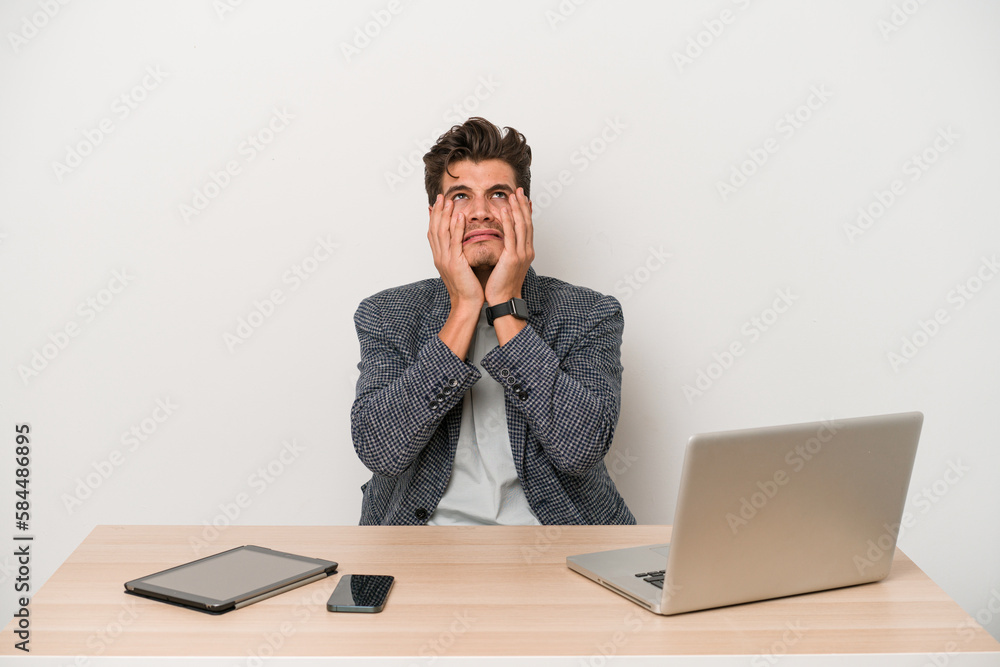Young entrepreneur man working with a laptop isolated crying, unhappy with something, agony and confusion concept. Young entrepreneur man working with a laptop isolated crying, unhappy with something, agony and confusion concept.