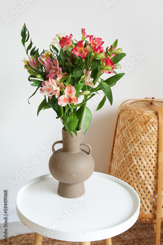 Vase with alstroemeria flowers on table in room, closeup photo