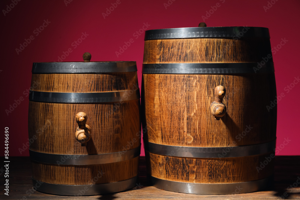 Wooden barrels on table near pink wall Wooden barrels on table near pink wall