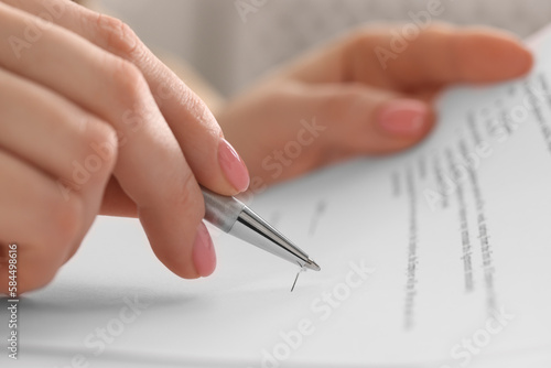Woman signing document with pen  closeup view
