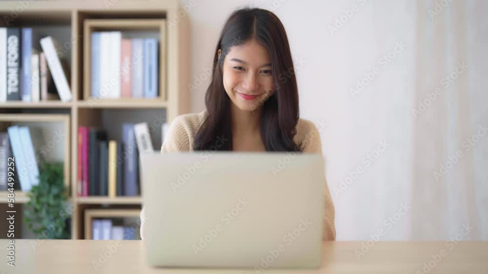 Young asian woman working at home. Female using computer laptop on desk at house Young asian woman working at home. Female using computer laptop on desk at house