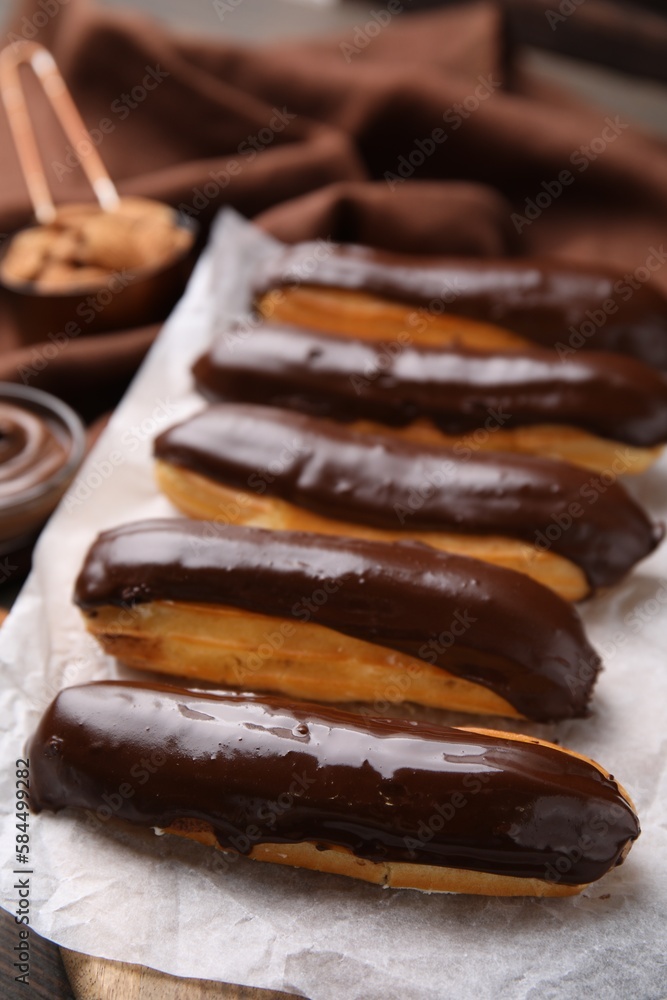 Delicious eclairs covered with chocolate on table Delicious eclairs covered with chocolate on table