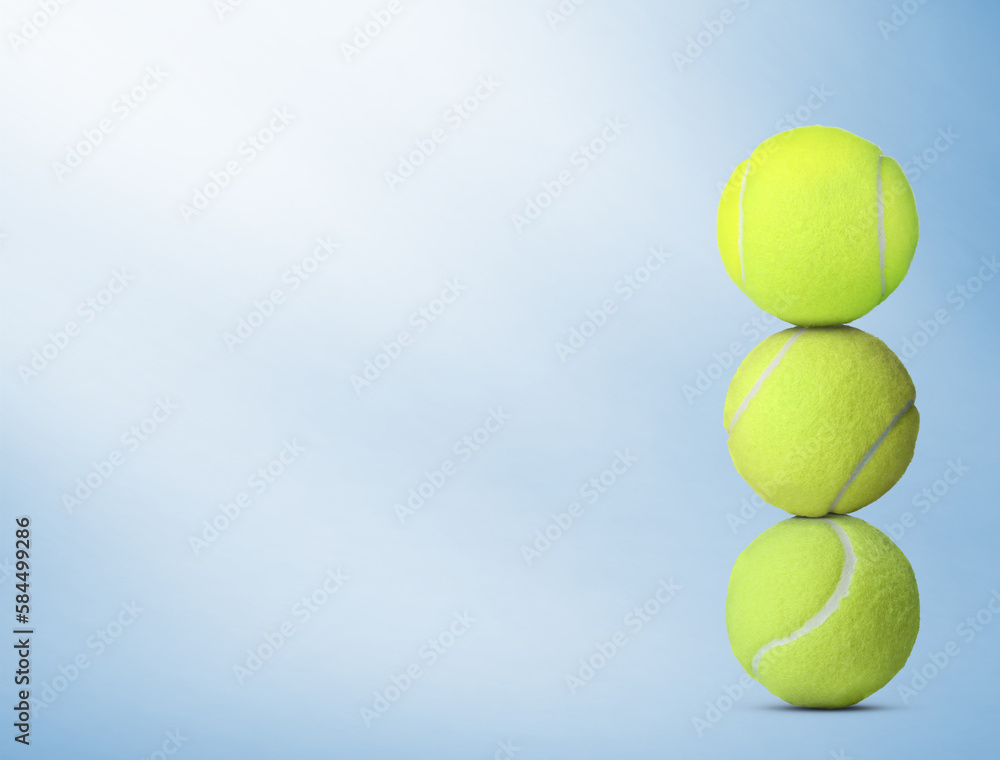 Stack of tennis balls on light blue background. Space for text