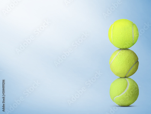 Stack of tennis balls on light blue background. Space for text © New Africa