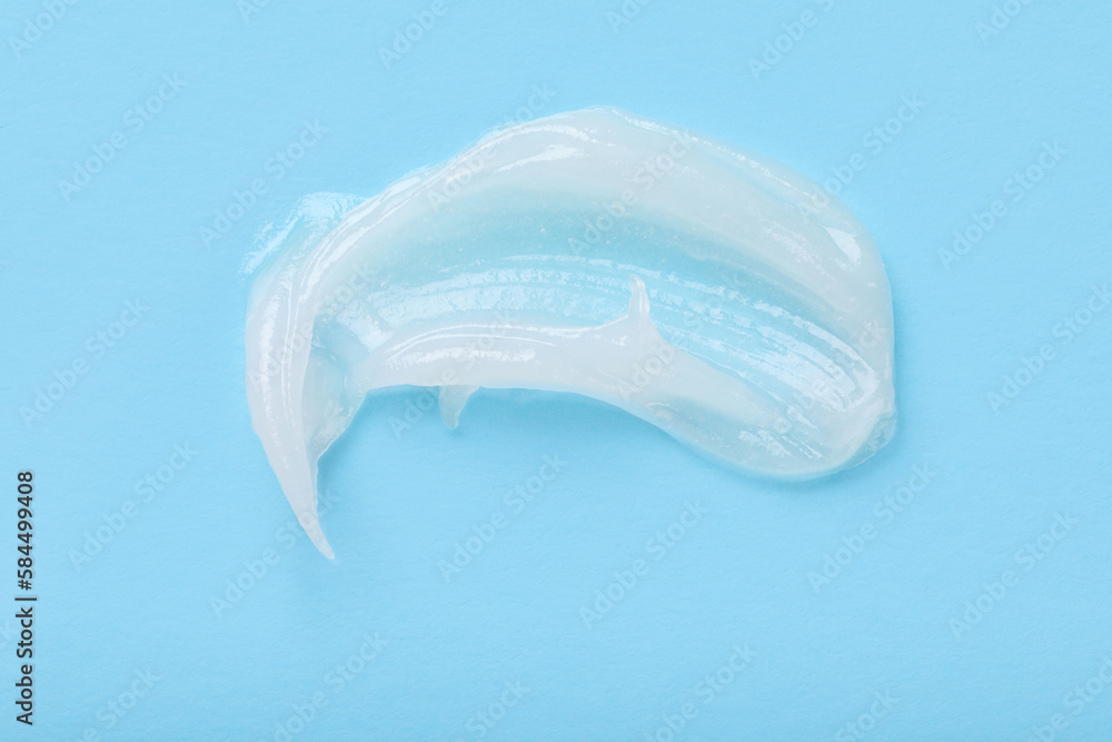Smear of ointment on light blue background, top view