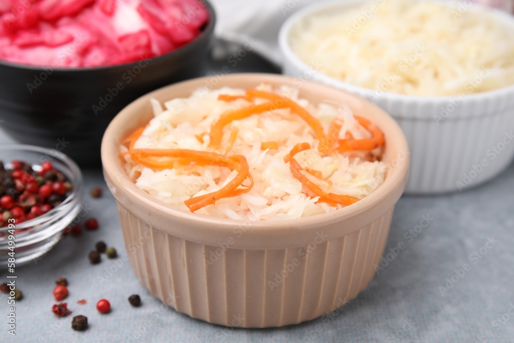 Delicious sauerkraut prepared according to different recipes on light gray table, closeup Delicious sauerkraut prepared according to different recipes on light gray table, closeup