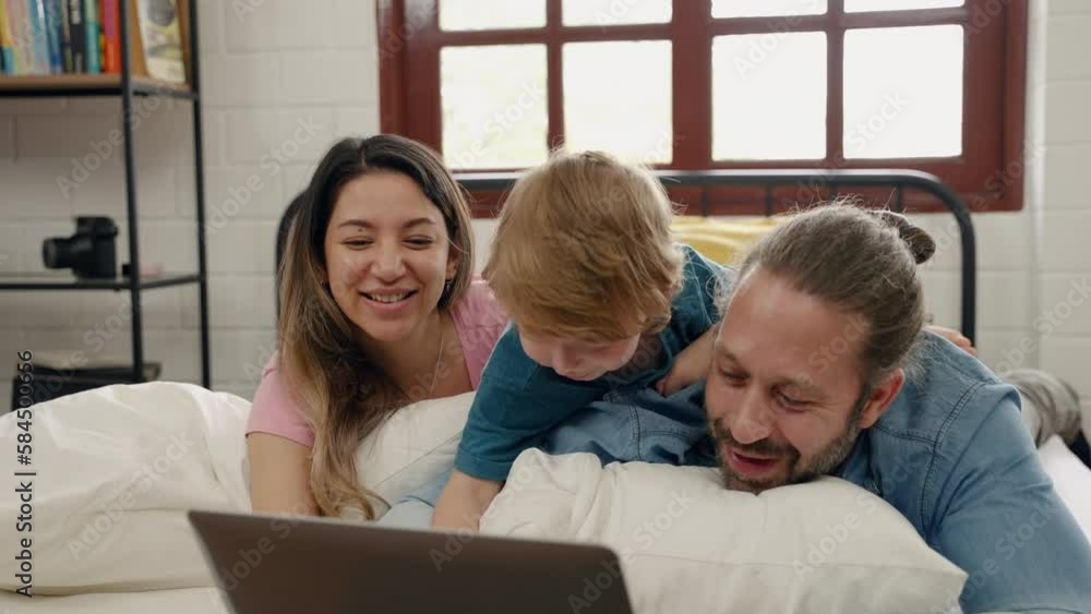 Father and mother teasing son in bed, family relationship concept
Father and mother teasing son in bed, family relationship concept