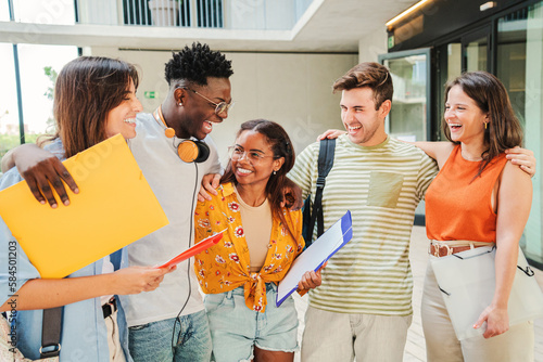Group of multiracial students talking and smiling after class at university campus. Diverse tenagers laughing and having fun at the breack of the high school. Education concept. High quality photo photo