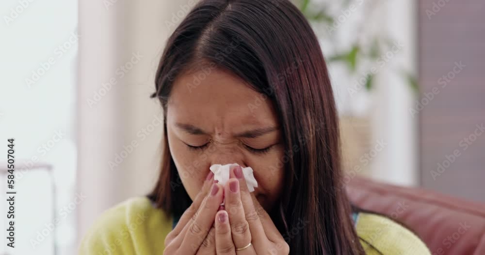 Covid, blowing nose and allergies with an asian woman in the living room of her home while on sick leave. Health, virus and sneezing with a female in her apartment, suffering from hay fever or sinus Covid, blowing nose and allergies with an asian woman in the living room of her home while on sick leave. Health, virus and sneezing with a female in her apartment, suffering from hay fever or sinus