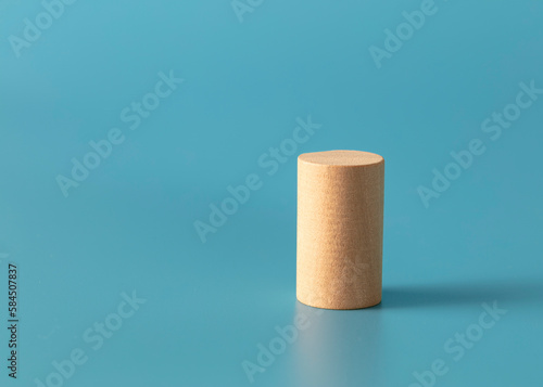 Geometric wood cylinder shape on blue background. 