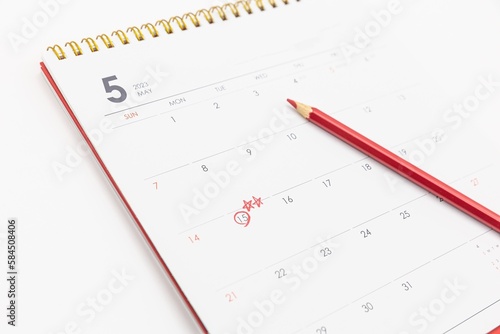 There is a calendar with a white background and a red pencil on a white background. A colored pencil in red marks the May 15th of the calendar. May 15th is Teacher's Day in Korea, Asia.