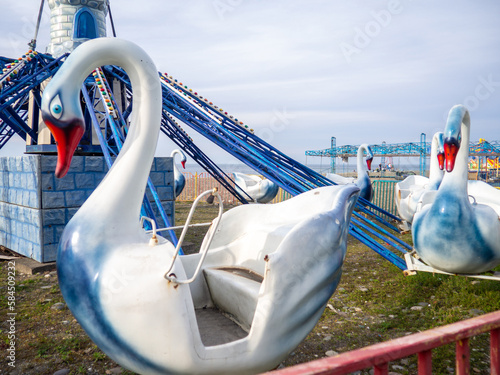  Swans on a carousel. Abandoned Luna Park on the seashore. A crisis. Old carousels. Not working. Broken attraction. resort in winter. Broken business. Emptiness.