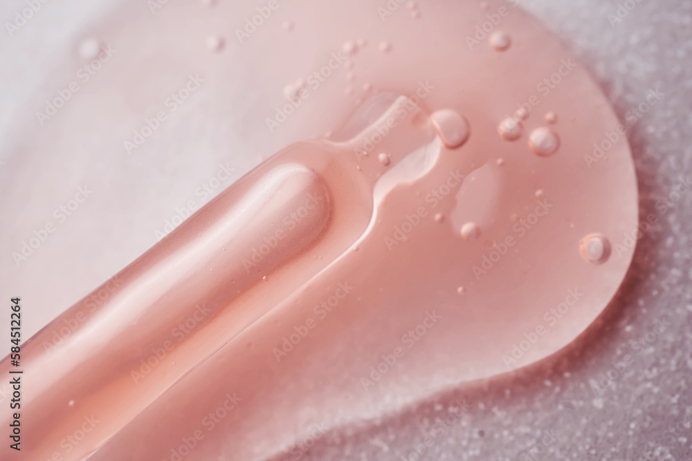 Fototapeta premium A pipette with a viscous pink cosmetic lies in a drop.
