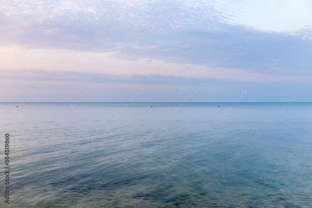 Background of sky and sea, sea is very calm with gentle ripples, sky perfectly clear.