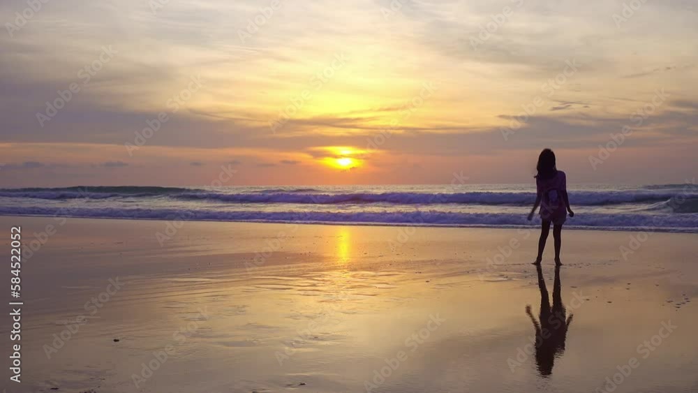 Silhouette of the young girl jumping on the beach and raise their hands up on the beach at sunset, Amazing light sunset or sunrise sky, Baby girl happy and relax watching sea landscape nature view Silhouette of the young girl jumping on the beach and raise their hands up on the beach at sunset, Amazing light sunset or sunrise sky, Baby girl happy and relax watching sea landscape nature view