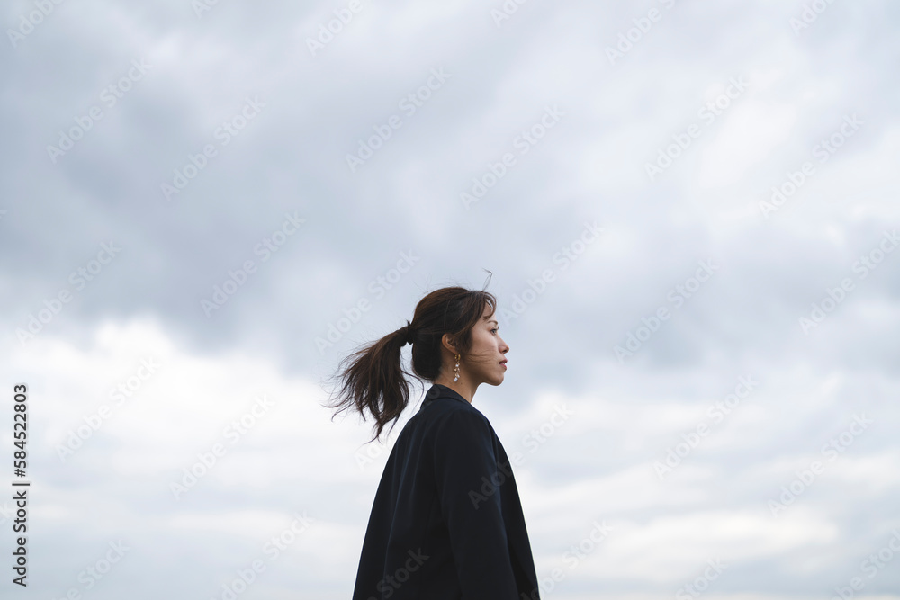 曇りの日の海にいるポニーテールの女性 曇りの日の海にいるポニーテールの女性
