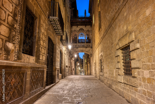Small alley in the Gothic Quarter in Barcelona at night with the Pont del Bisbe photo