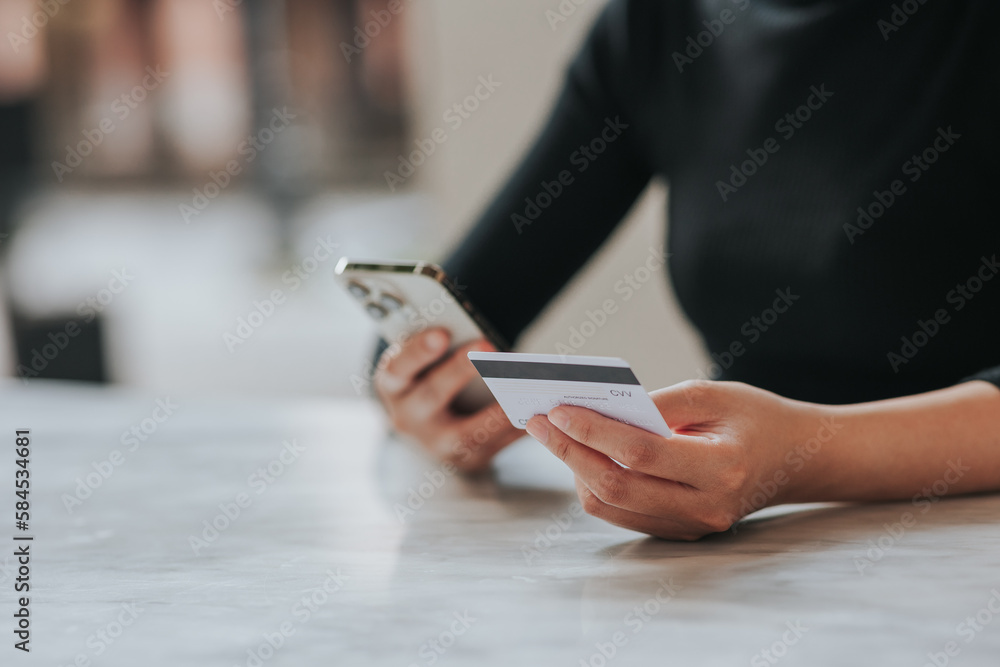 online payment Young woman's hand holding a credit card and using a smartphone for online shopping. online payment Young woman's hand holding a credit card and using a smartphone for online shopping.