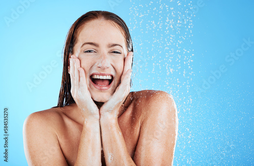 Woman in shower, happy in portrait with hygiene and water drops, soap and clean with excited face on blue background. Facial, hydration and skincare with female cleaning body, foam and mockup space