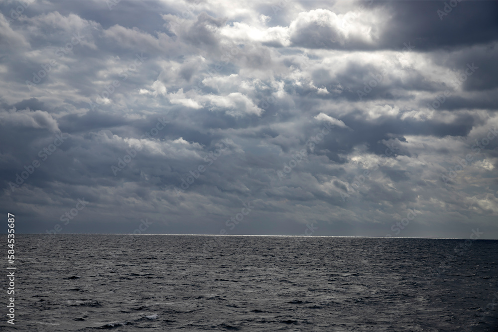 Fototapeta premium Sea with dramatic rainy clouds and sun beams.