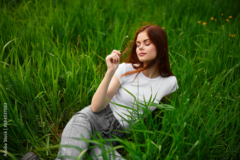 woman in gray jeans resting lying in the grass woman in gray jeans resting lying in the grass