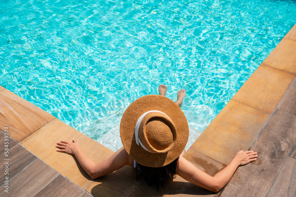 Top view of woman wear a hat sitting and relaxing in swimming pool ...