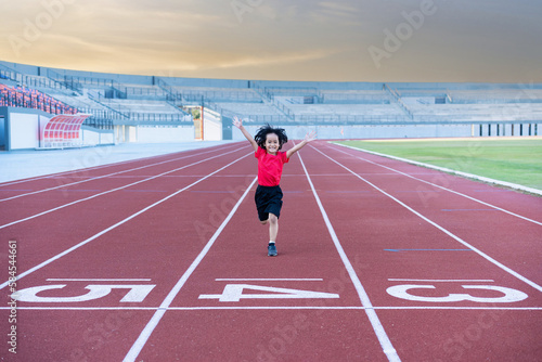 Little girl at athletics competition race. A girl running in stadium.