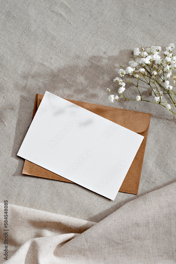 Blank paper card with mockup copy space, envelope and flowers on neutral beige background, aesthetic wedding invitation or greeting card, letter template Blank paper card with mockup copy space, envelope and flowers on neutral beige background, aesthetic wedding invitation or greeting card, letter template