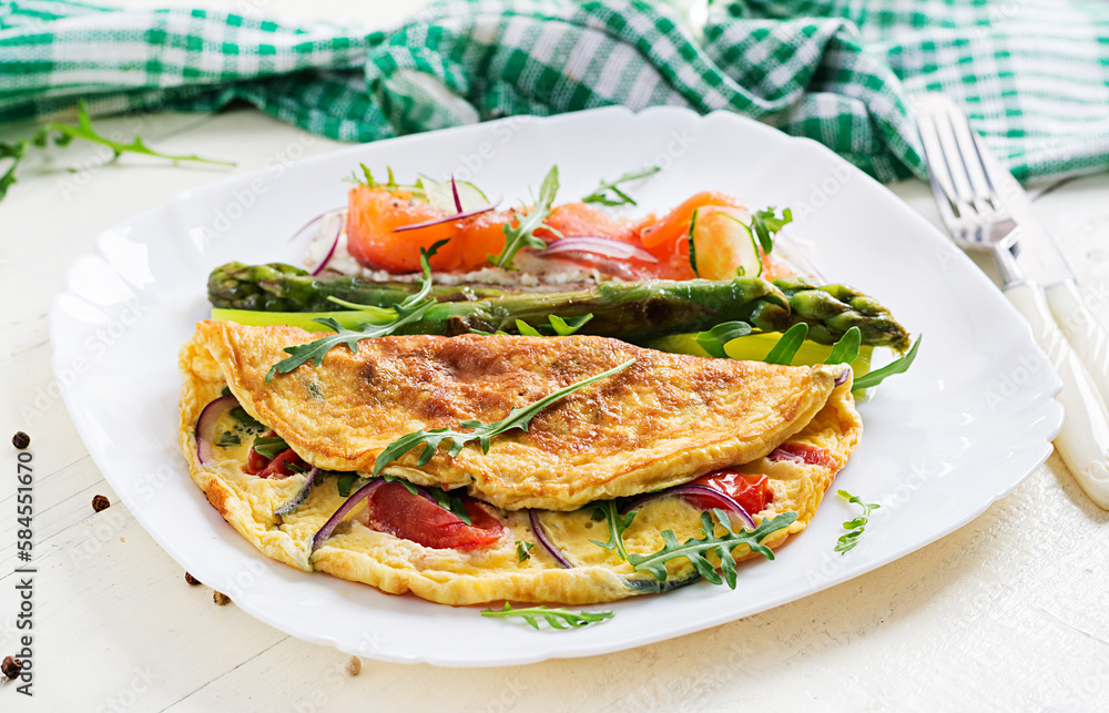 Ketogenic breakfast. Omelette with tomatoes, red onion, sandwich with salmon and roasted asparagus. Italian frittata. Keto, ketogenic lunch.