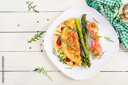 Ketogenic breakfast. Omelette with tomatoes, red onion, sandwich with salmon and roasted asparagus. Italian frittata. Keto, ketogenic lunch. Top view, flat lay