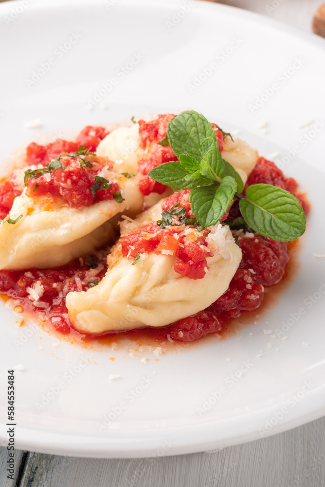 Culurgionis ogliastrini conditi con pomodoro e pecorino, cibo tradizionale sardo, pasta italiana Culurgionis ogliastrini conditi con pomodoro e pecorino, cibo tradizionale sardo, pasta italiana