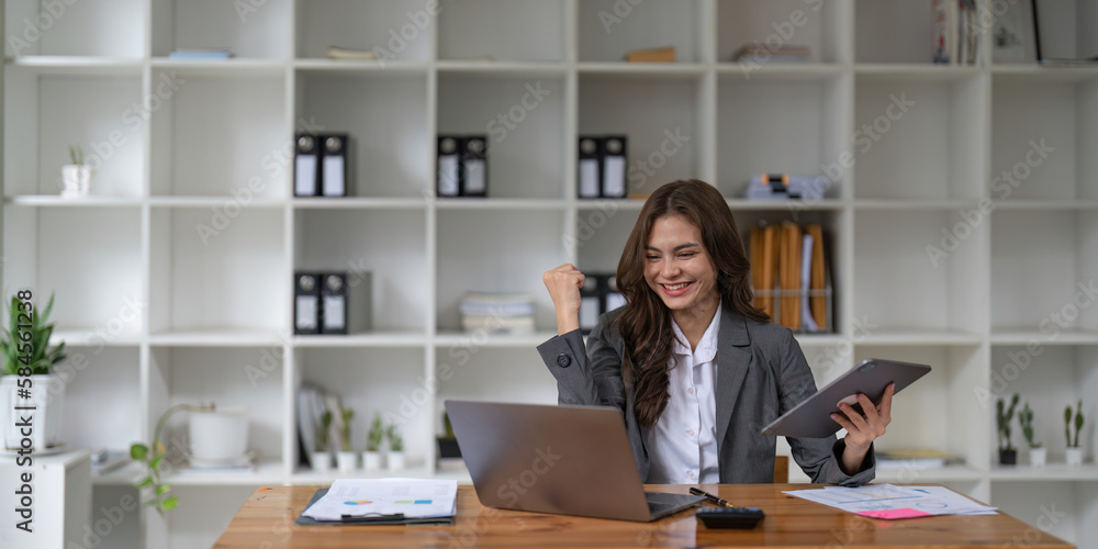 Happy woman office worker feeling excitement raising fists celebrates career ladder promotion or reward, businesswoman sitting at desk receive online news, great results successful work concept