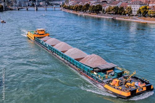 Self propelled barge carrying construction material in River Rhine, Basel, Switzerland