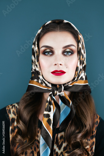A woman in a scarf on a gray background