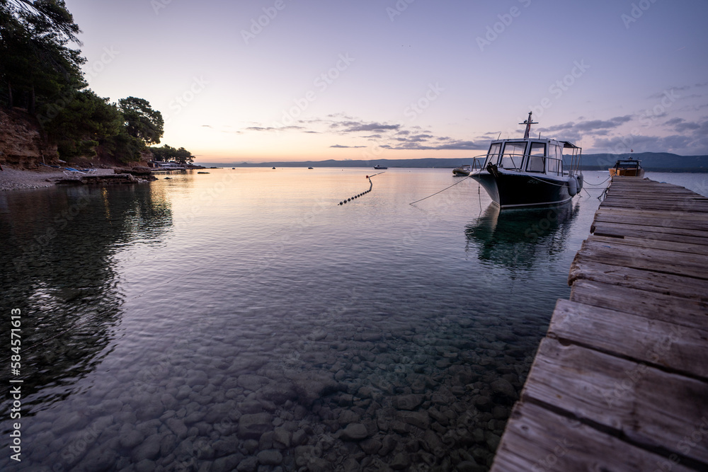 sunset over the sea with a boat in Bol, Island of Brac, Croatia sunset over the sea with a boat in Bol, Island of Brac, Croatia