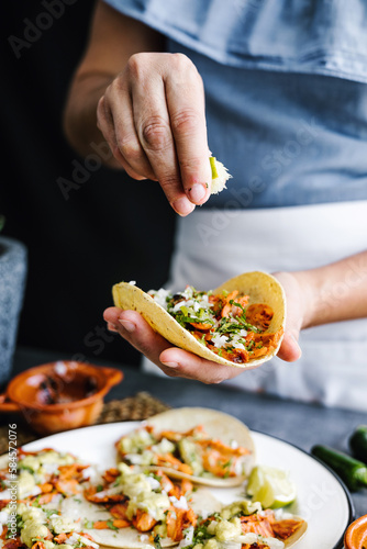 Canvas Print Mexican woman hands preparing tacos al pastor and eating mexican food in Mexico