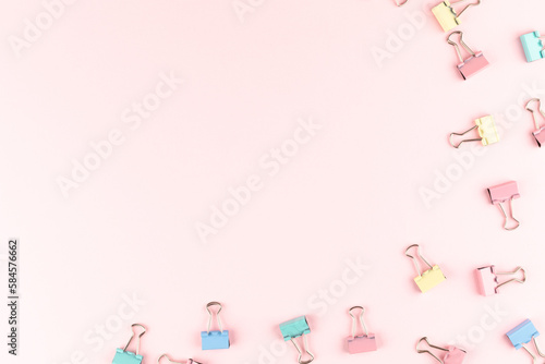 colorful binder clip on pink background photo