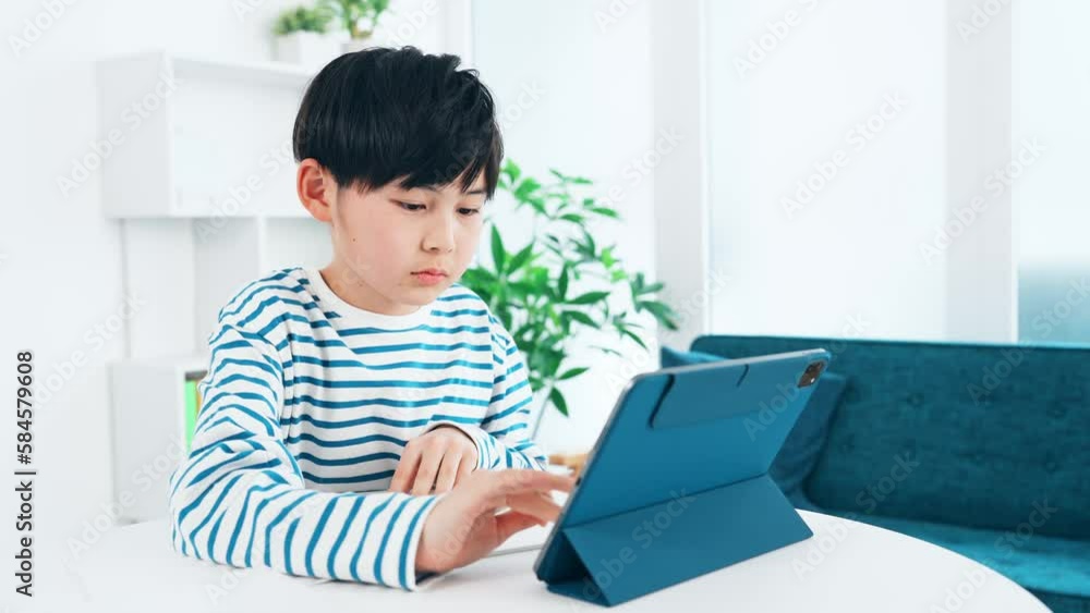 タブレットを見ながら勉強する男の子 タブレットを見ながら勉強する男の子