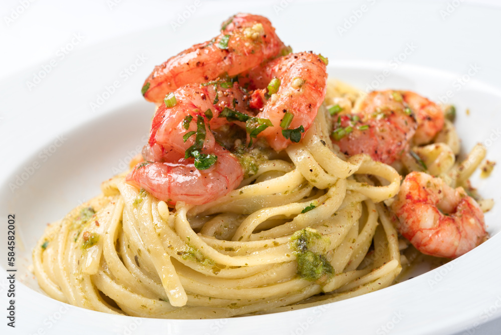 Primo piano di deliziose linguine condite con pesto e gamberi, cibo italiano Primo piano di deliziose linguine condite con pesto e gamberi, cibo italiano