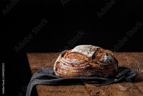 Rustic crispy sourdough bread with cranberries on a wooden table