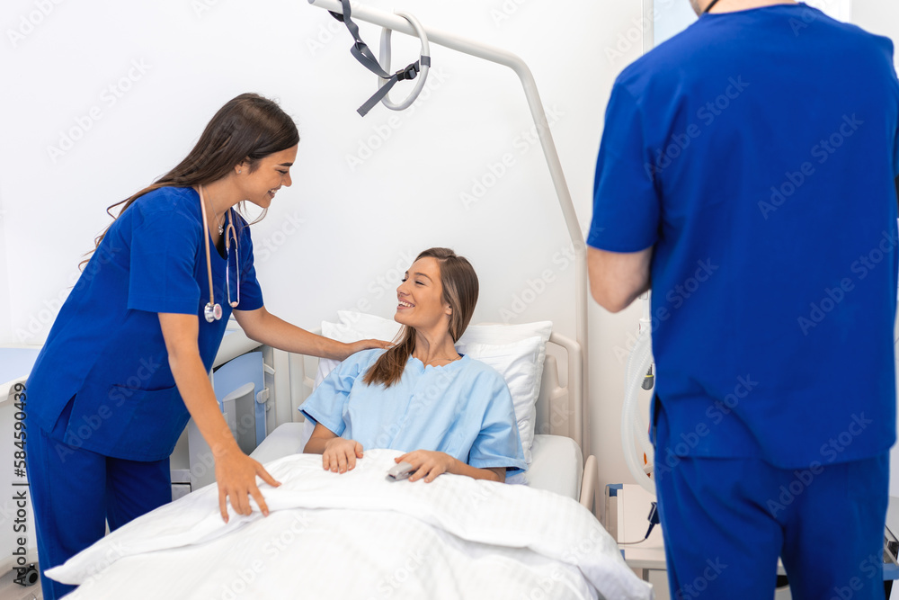 Obraz premium Hospitalized woman lying in bed while doctor checking on her. Doctor and nurse examining female patient in hospital room.