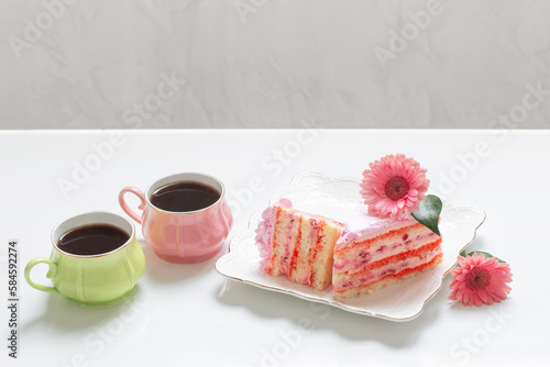 two cups of tea with pink cake on white table