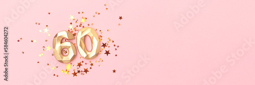 Banner with gold colored number sixty and stars confetti on a pink background. Creative concept with copy space. photo